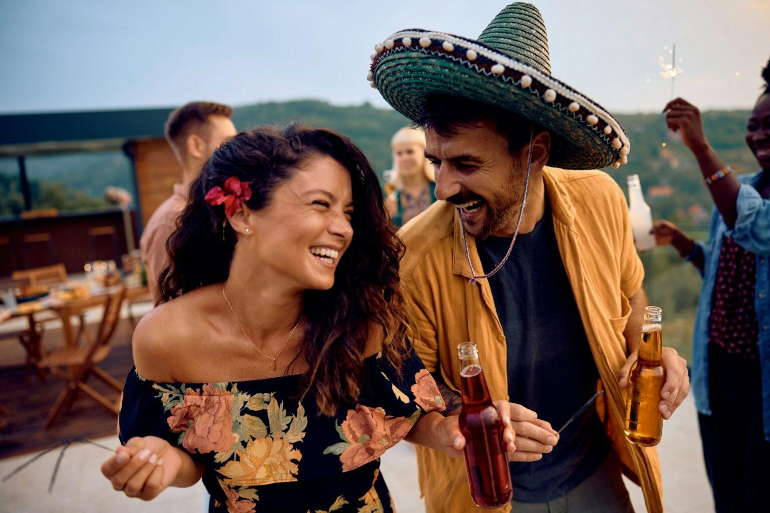 L’amitié entre homme et femme : mythe ou réalité ? Happy couple having fun while dancing on a party with friends on a patio.