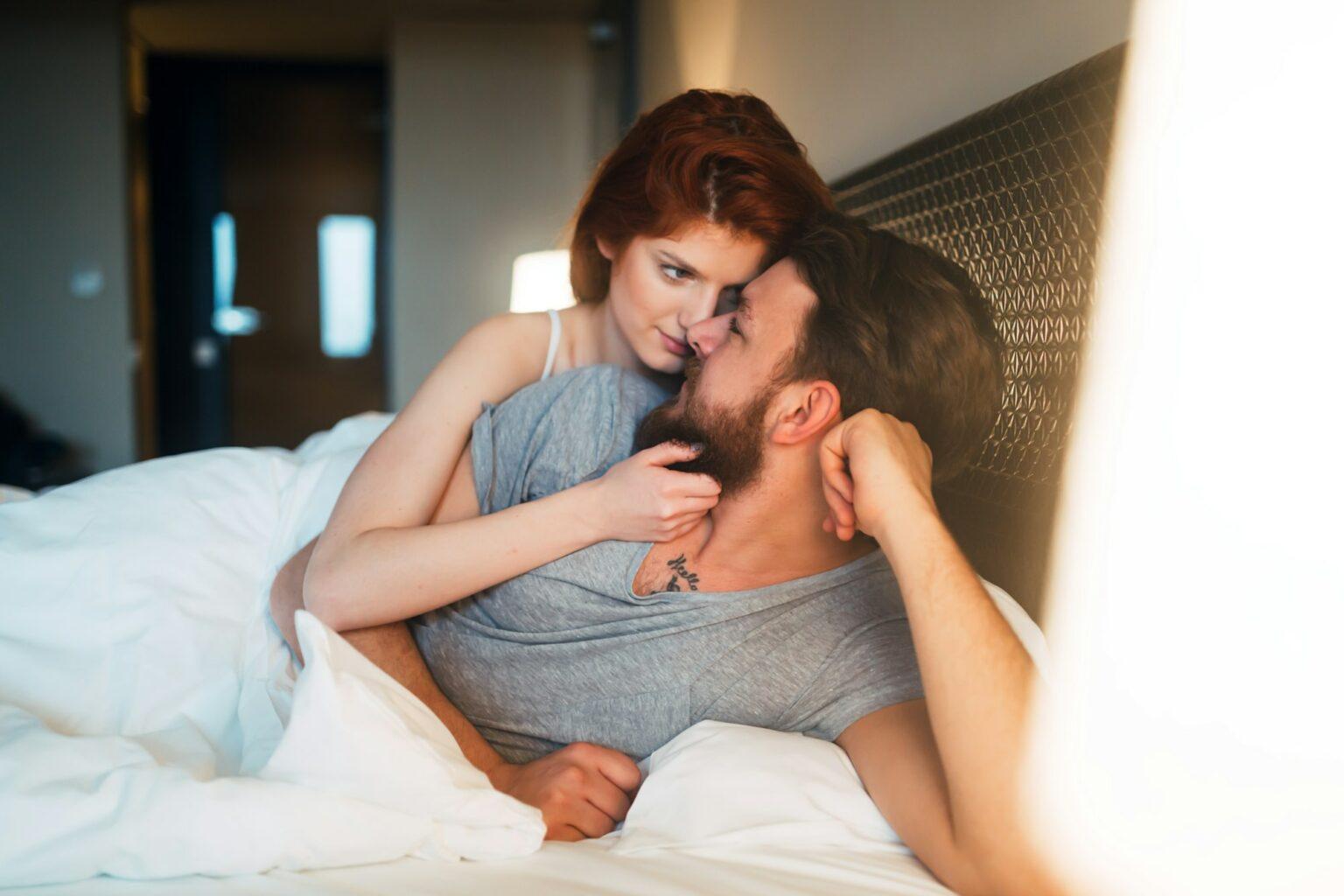 Happy couple in bed showing emotions and happy