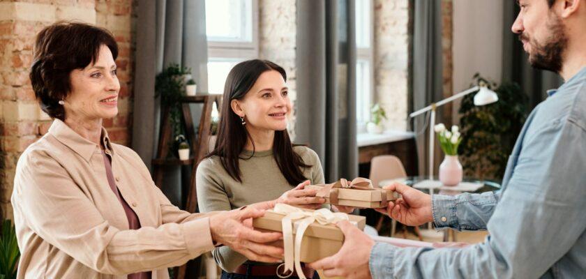 Young man giving presents to his wife and mother-in-law