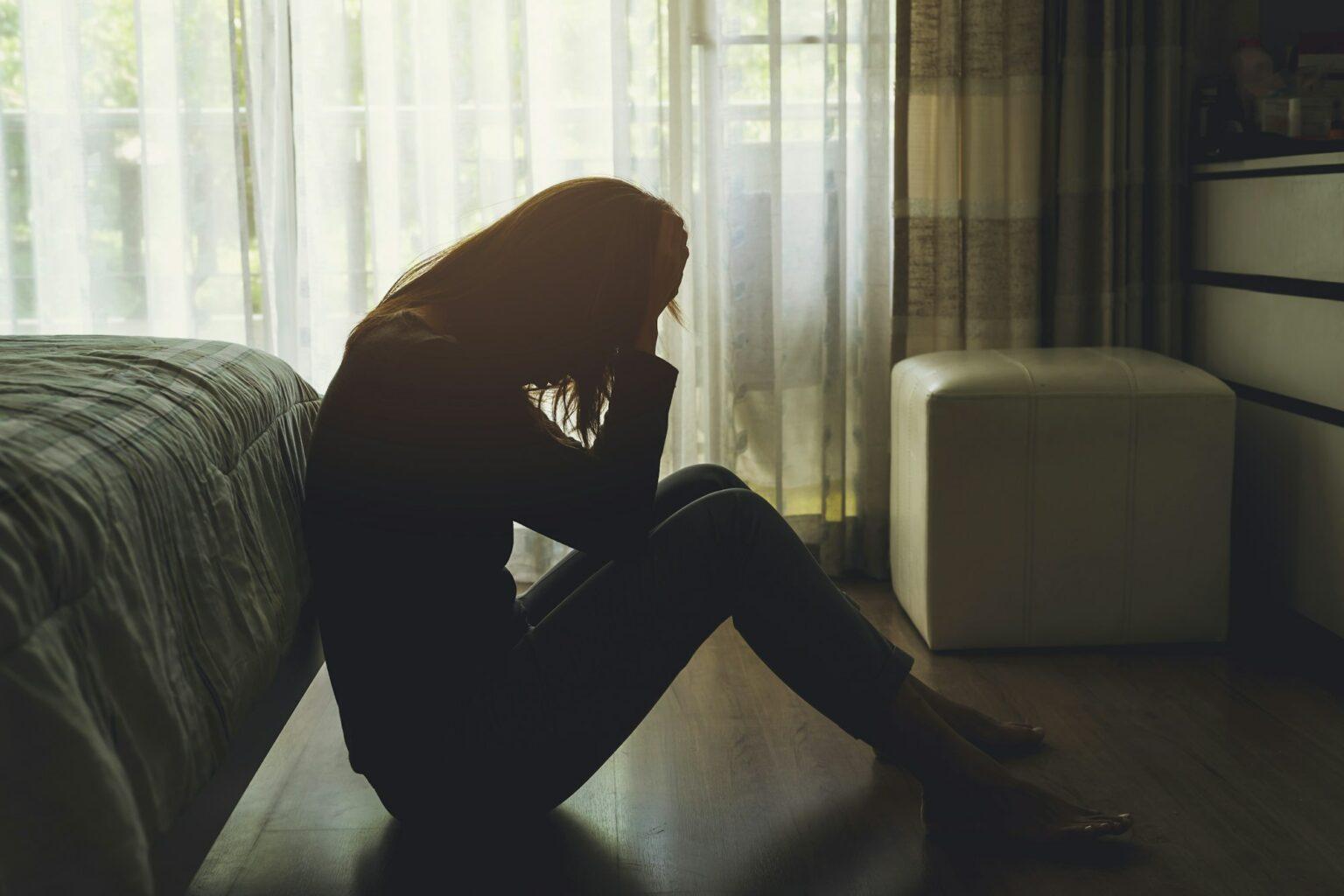Choisir la tristesse : L’ironie de la dépression depressed woman sitting in the dark bedroom