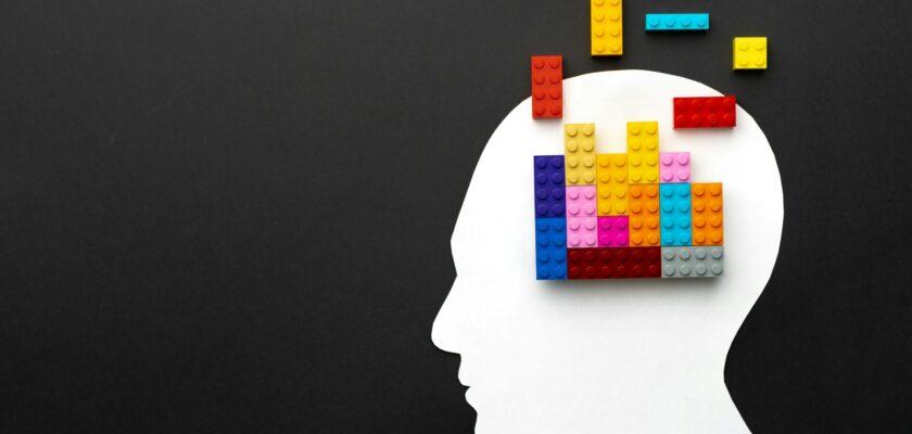 Papercut silhouette of human head with colorful constructor pieces