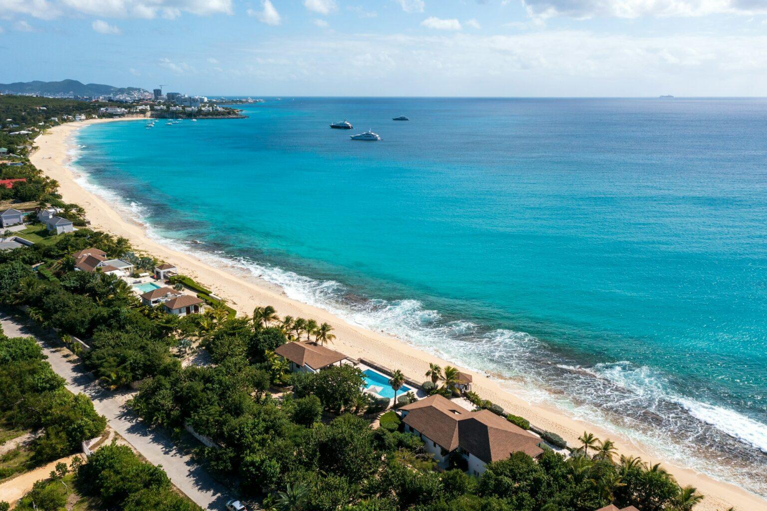Vivre près de la mer : la clé du bonheur selon la science an aerial view of a beach with houses in the foreground