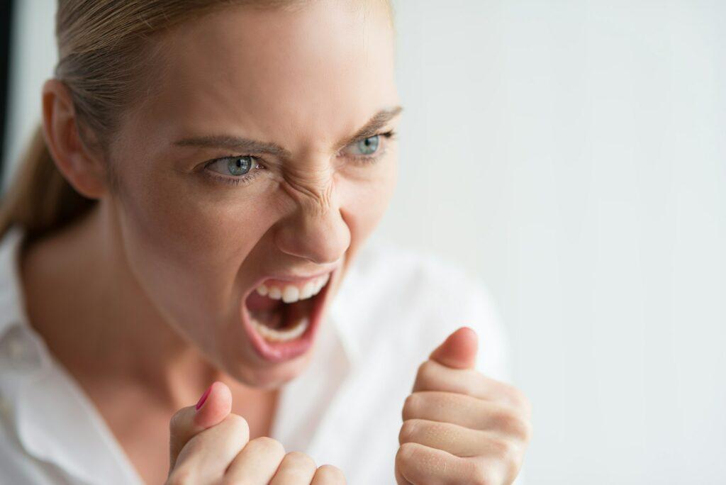 Emotion Concept. Woman standing isolated on white screaming angry close-up