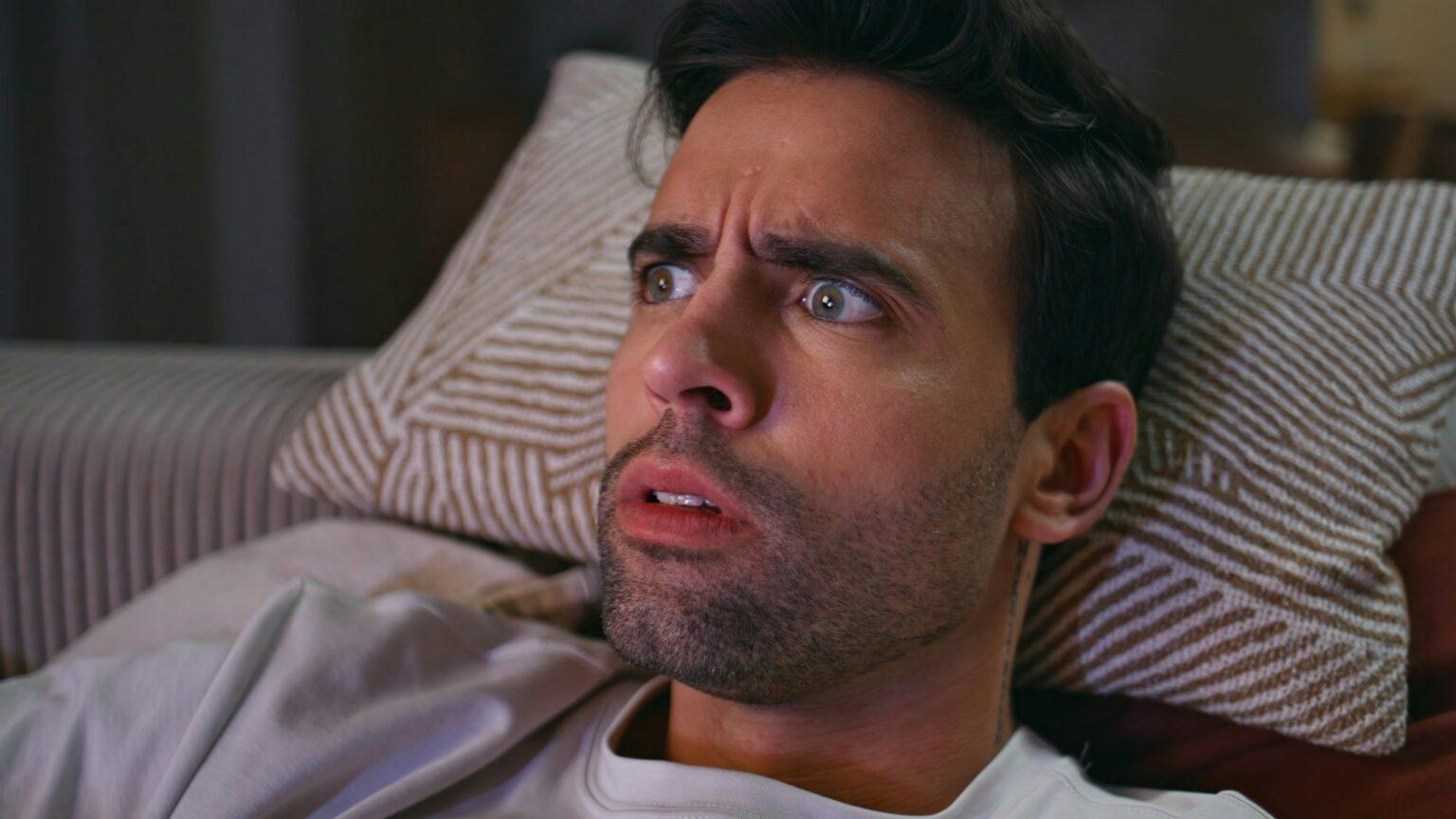 L’exposition répétée aux images médiatiques d’événements traumatisants peut nuire à la santé Guy looking TV horror lying sofa pillows feeling scared in night home closeup.