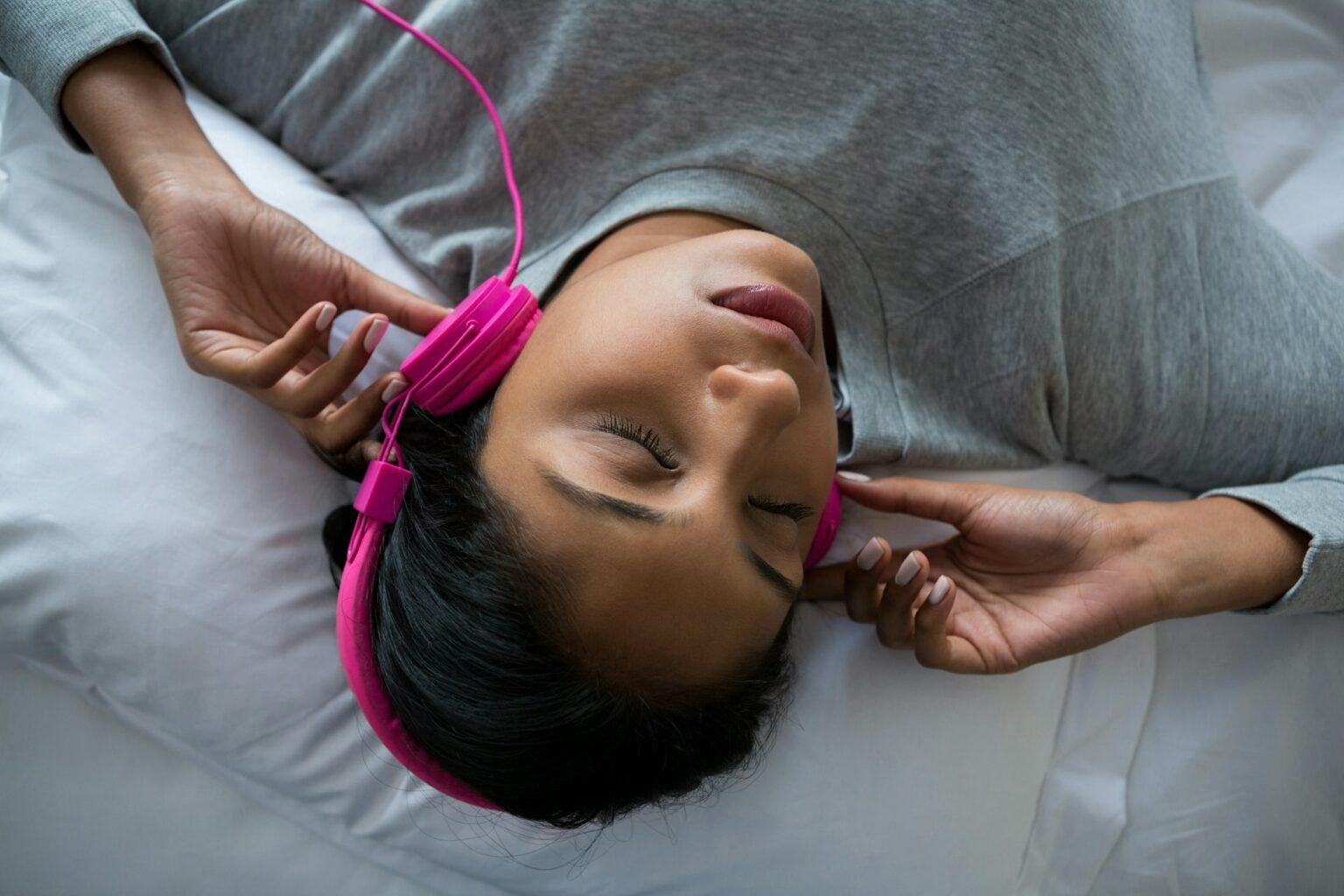 Écouter de la musique avant de dormir : un piège à vers d’oreille perturbateurs de sommeil Woman listening to music while sleeping on bed