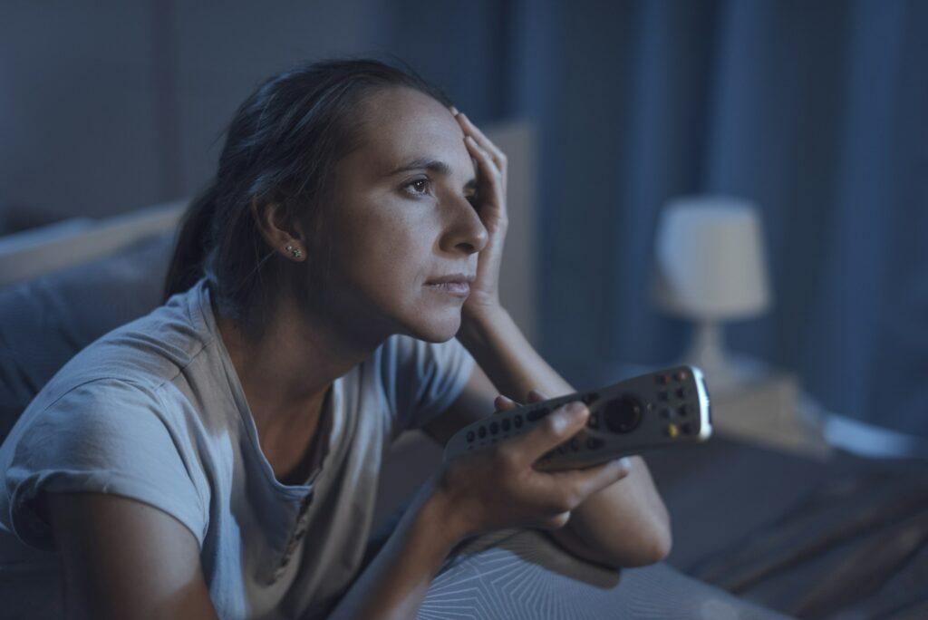 Woman lying in bed and watching TV