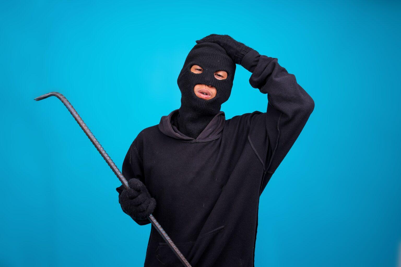 Le syndrome de Stockholm : comprendre un phénomène mystérieux Frustrated Robber Touching His Head While Holding Crowbar Isolated on Blue Background