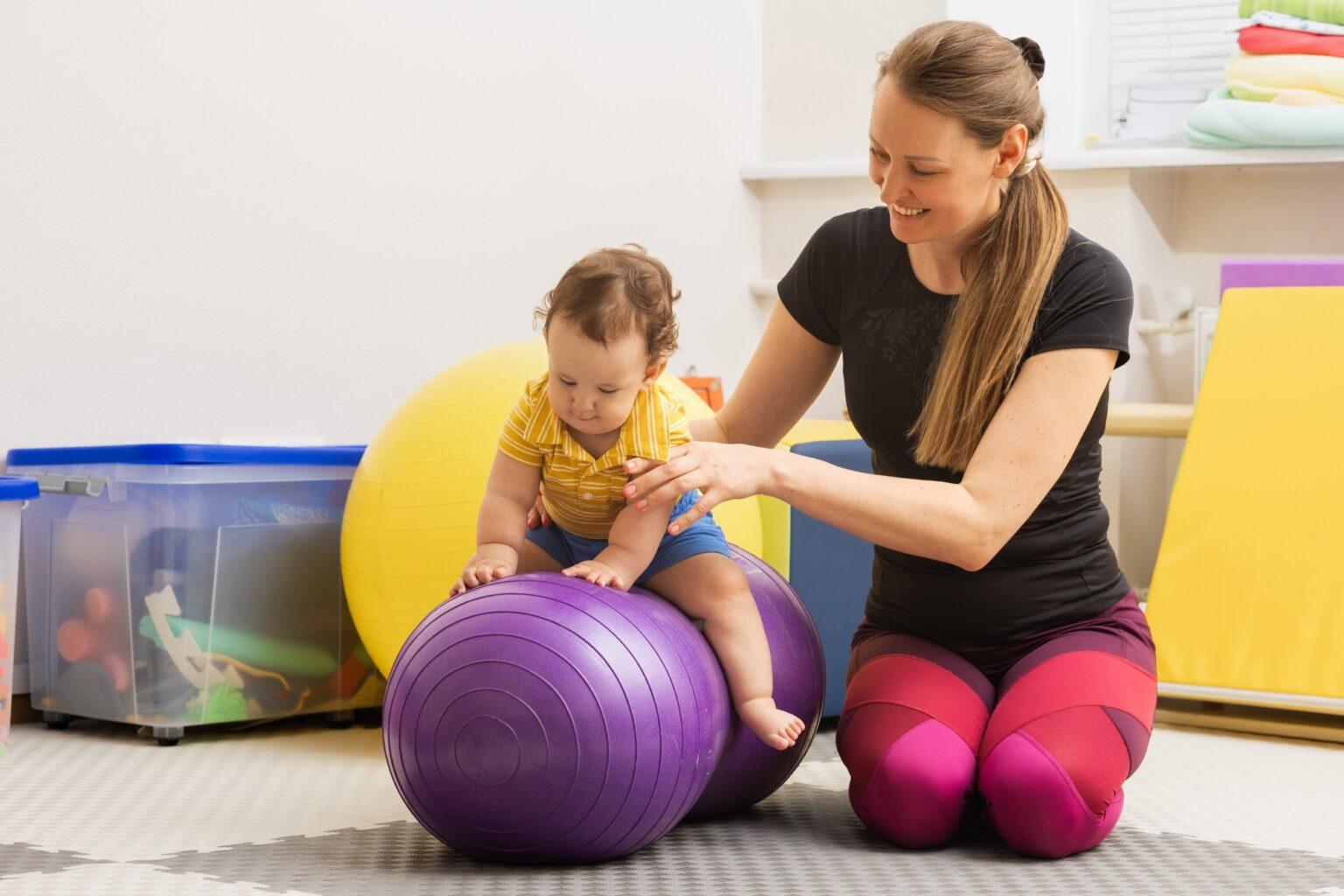 Comprendre la lapraxie : un trouble de mouvement méconnu Male child with movement disorders engages in rehabilitation therapy with specialist at children's