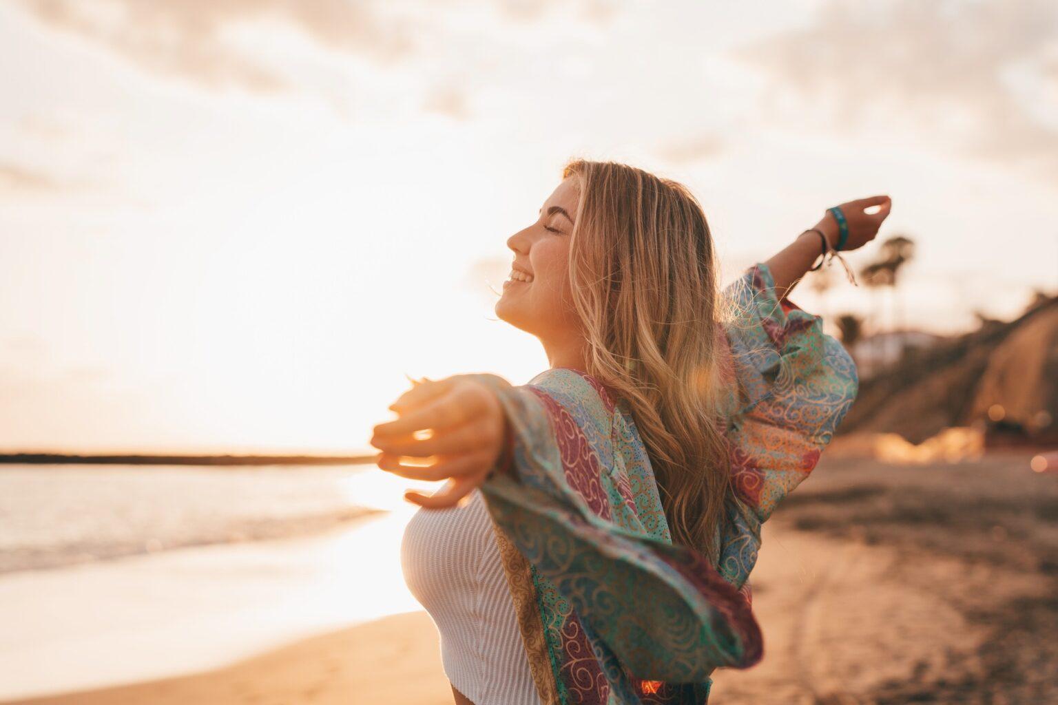 Lâcher prise pour reconquérir son ex : la clé d’une démarche authentique Portrait of one young woman at the beach with openened arms enjoying free time and freedom