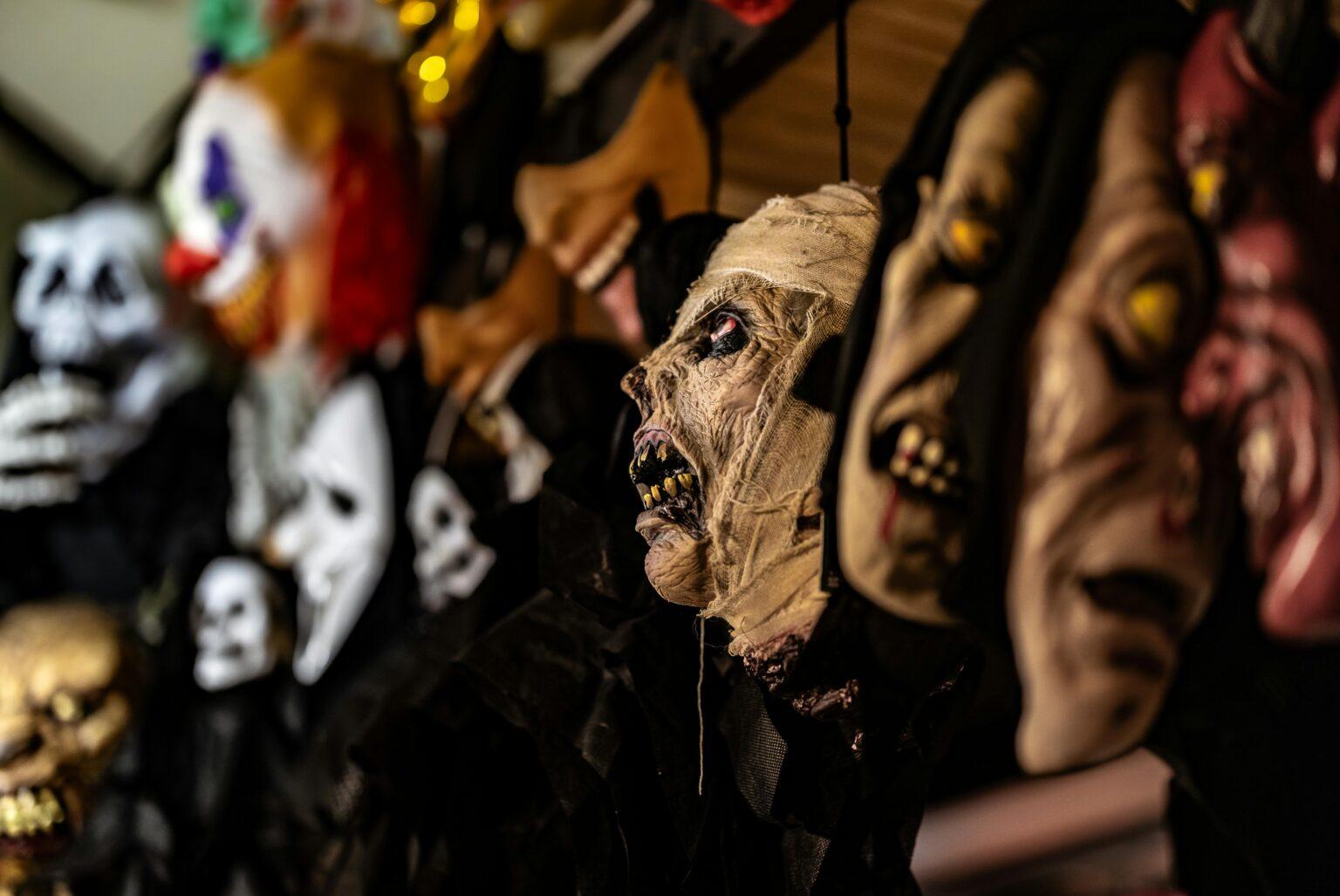 A collection of eerie Halloween masks displayed in a creepy setting, perfect for horror and thriller themes.