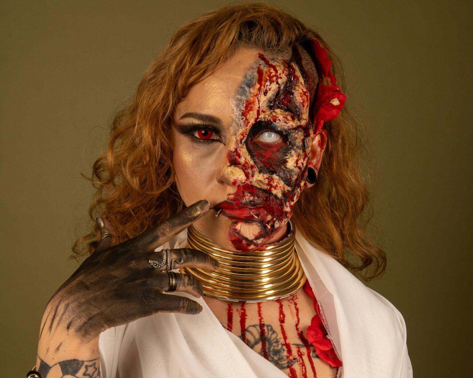 Close-up portrait of a person with elaborate horror-themed makeup and costume for Halloween.