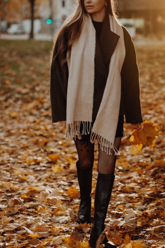 Comprendre la dysphorie prémenstruelle : symptômes et solutions Stylish woman strolls through a park with golden autumn leaves, holding a bouquet.