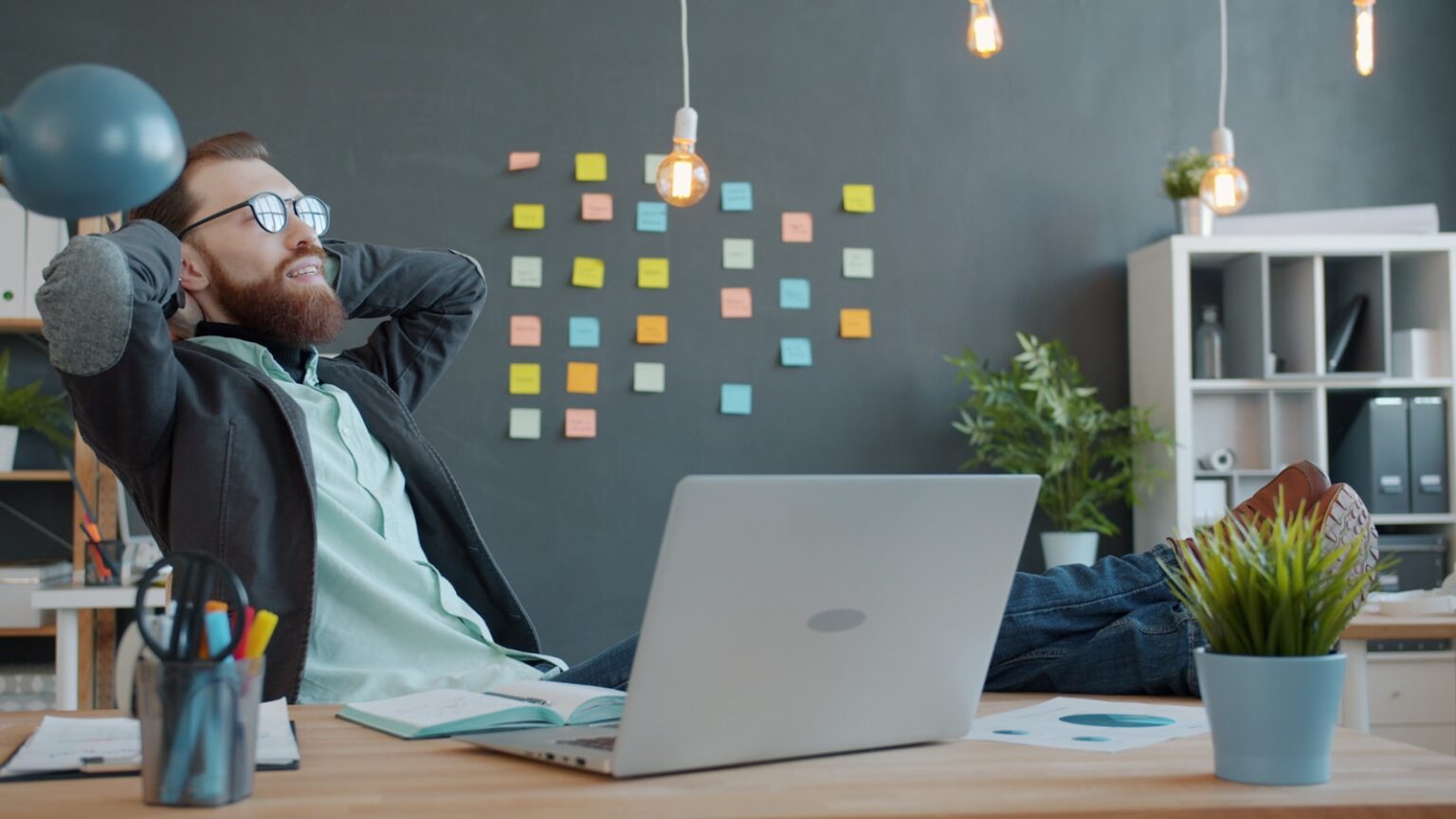 Le Job Crafting : Comment réinventer votre travail actuel pour qu’il ait du sens (sans démissionner) Man relaxing with feet on desk in office.