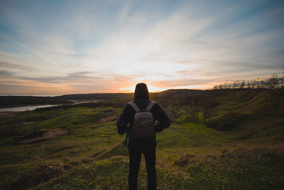 Personne observant un paysage naturel au lever du soleil