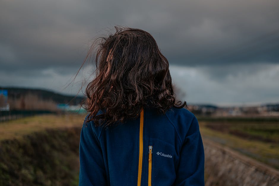 Person standing strong in a storm, symbolizing mental robustness