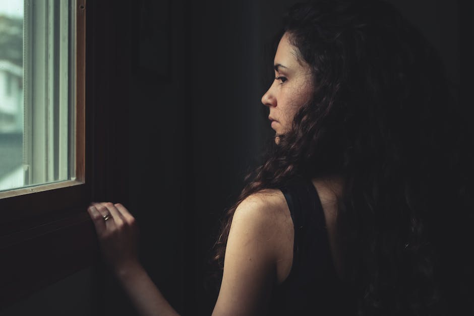 Person looking thoughtfully out a window, reflecting curiosity and life satisfaction
