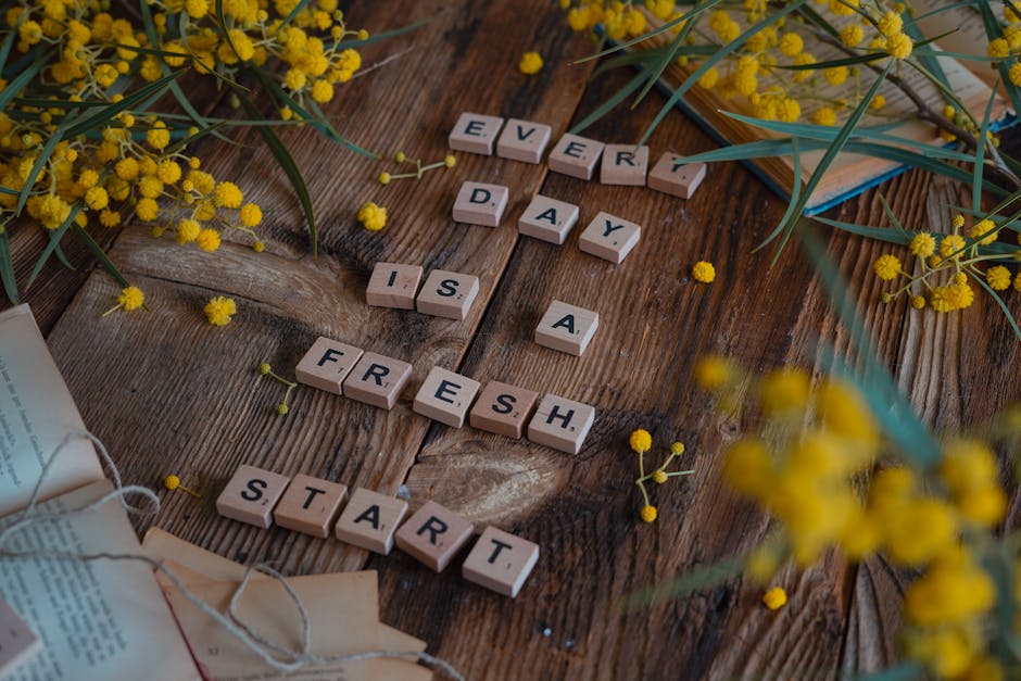 Micro-moments de positivité au quotidien : la science des petits gestes qui changent tout Wooden tiles spell 'Every day is a fresh start' surrounded by yellow flowers on rustic table.
