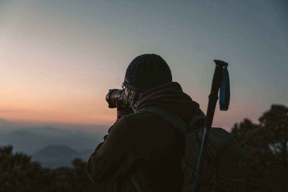 Person taking a photo at sunrise in a peaceful outdoor setting