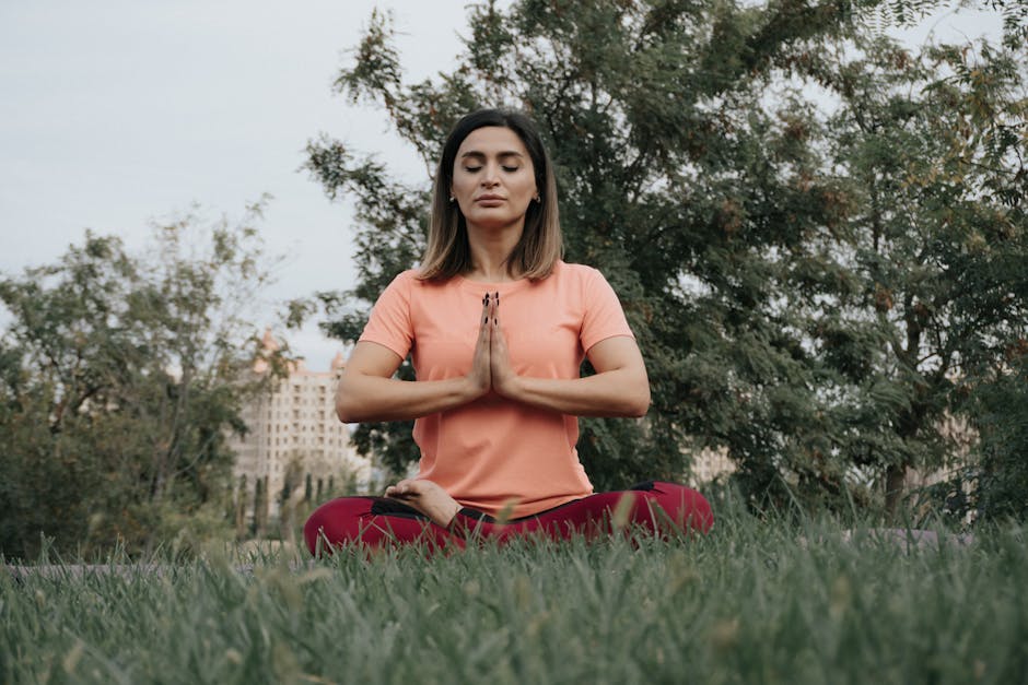 Person practicing meditation outdoors with a camera nearby