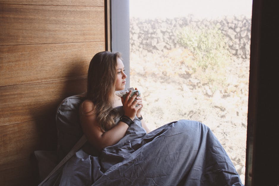 Person enjoying a quiet morning tea by a window