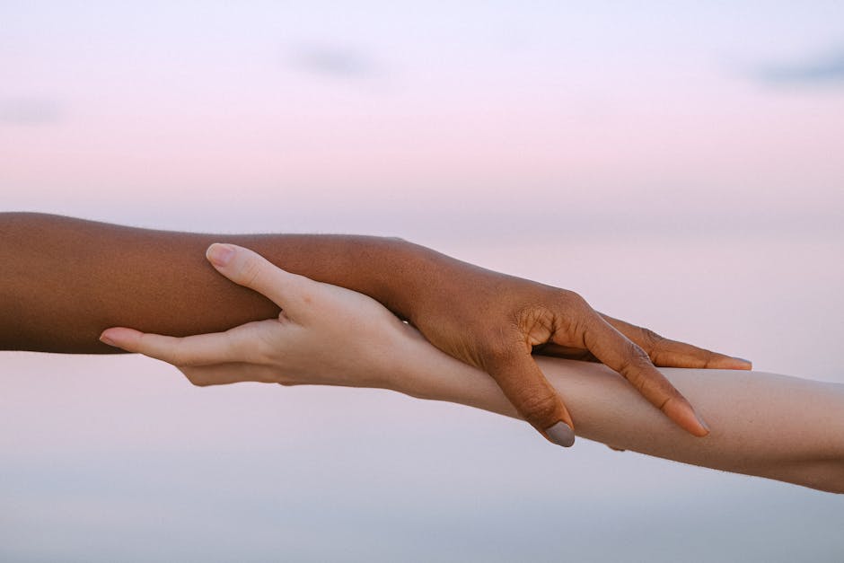 Mains diverses se tenant pour symboliser l'empathie, l'unité et le soutien dans un contexte de changement positif.