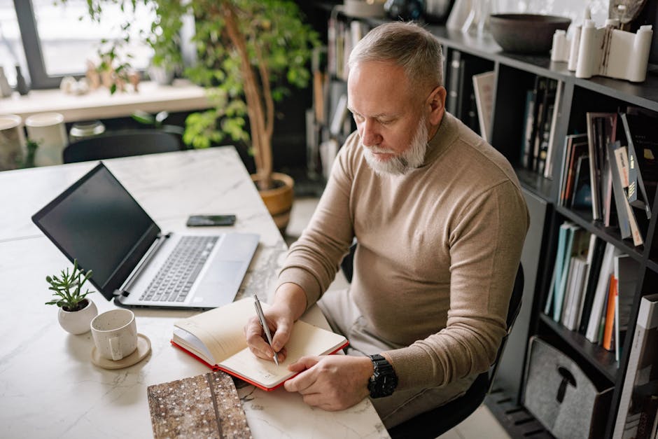 Elderly person writing in a notebook at home