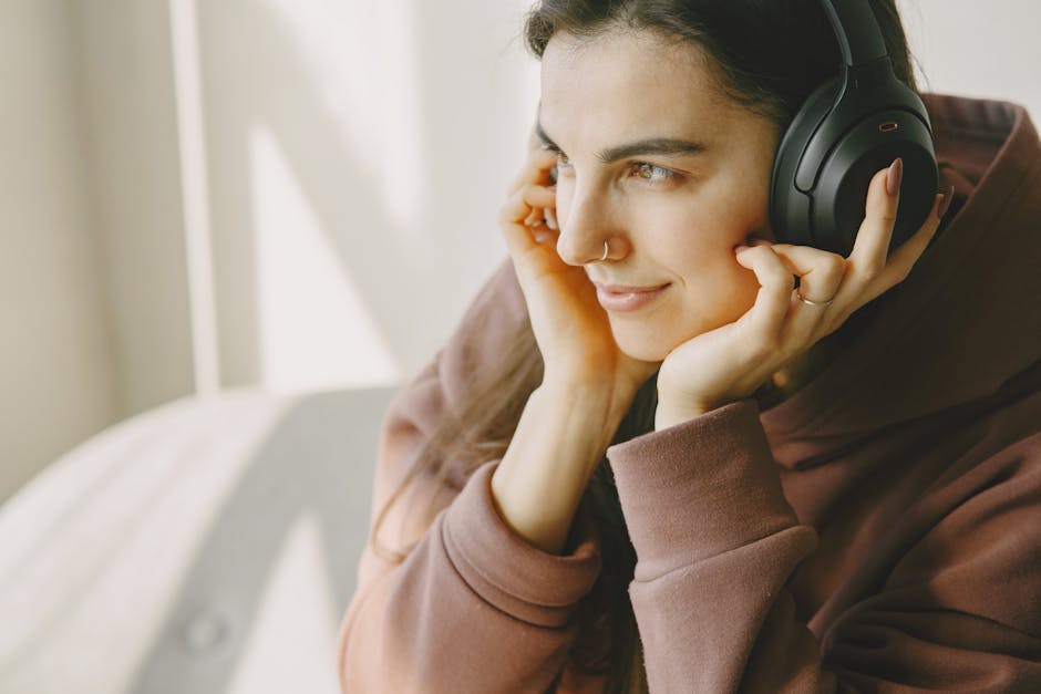 Person listening to music with headphones in a calm, reflective setting