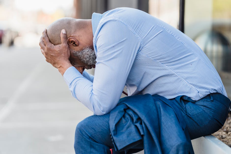 Stressed person sitting alone reflecting after losing a job