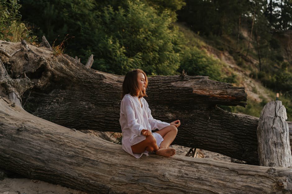 Person meditating in a calm natural setting, symbolizing mindfulness and presence