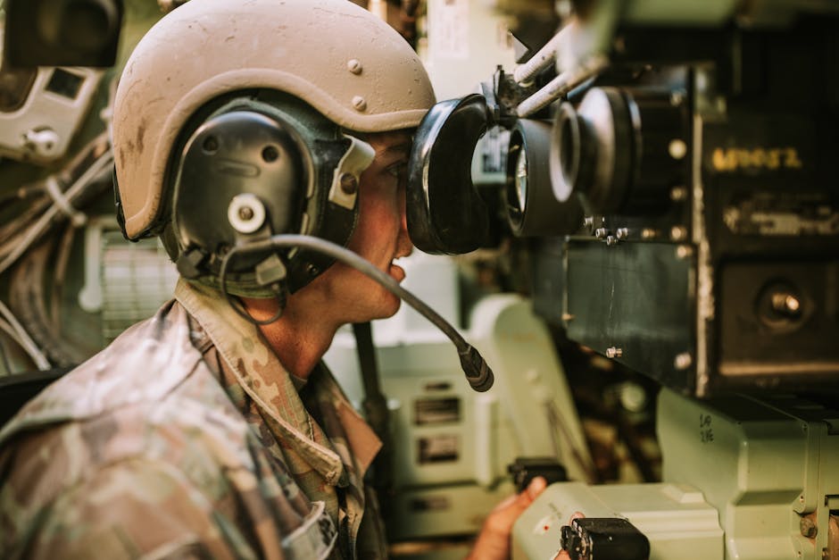 La créativité comme force psychologique mesurable : tests, cerveau et limites A soldier in uniform operates military equipment inside a vehicle, showcasing modern military technology.