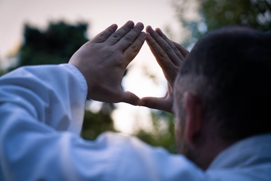Pleine conscience et vertus : l’approche fusionnée pour transformer votre vie Silhouette of a man forming a triangle with hands against an outdoor backdrop in Buenos Aires.