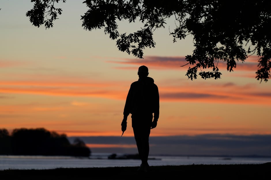 Person meditating while walking in a peaceful park at sunrise