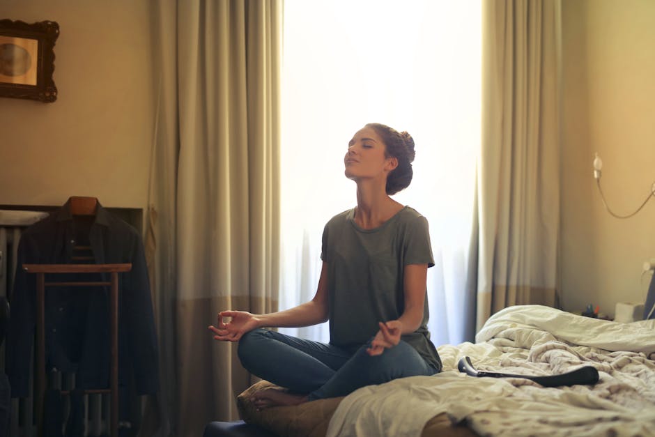 Person meditating calmly in a quiet bedroom before sleep