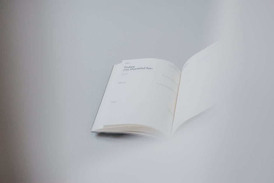 Person writing in a gratitude journal near a window with sunlight