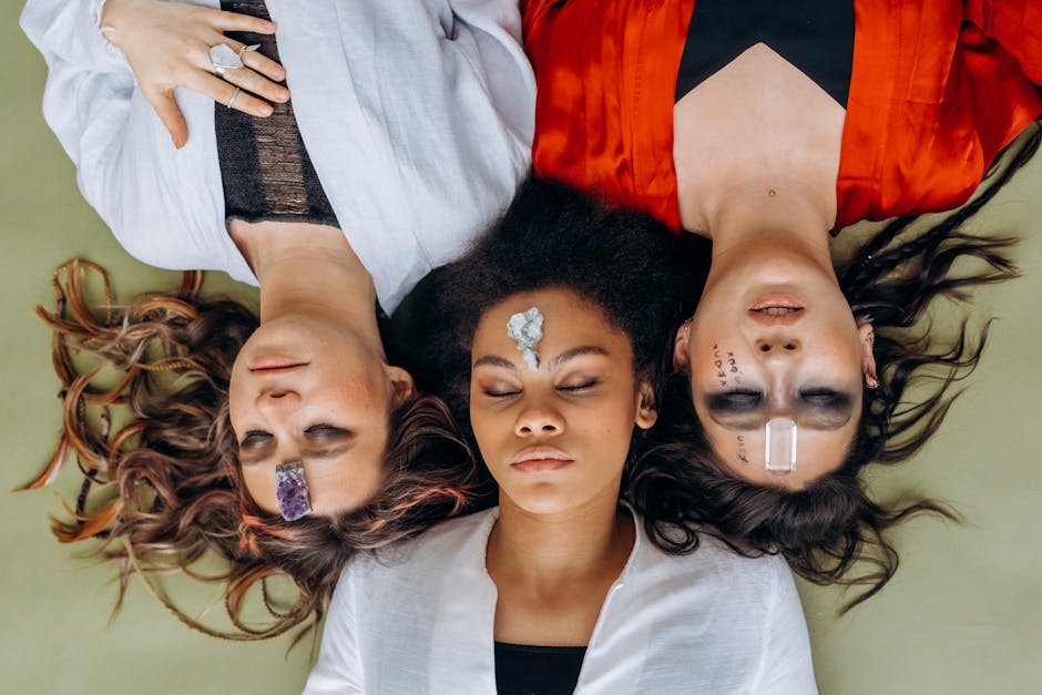 La transcendance : ces forces invisibles qui nous relient à plus grand que nous Three women lying on a mat with crystals on their foreheads, practicing mindfulness.