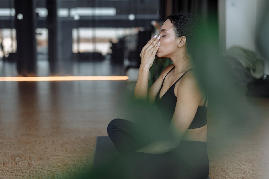 Person sitting cross-legged in a yoga pose and meditating