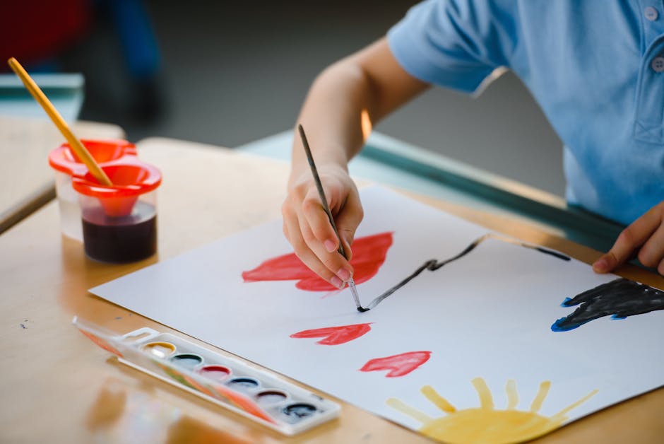 Children engaged in art therapy with paint and paper in a bright classroom