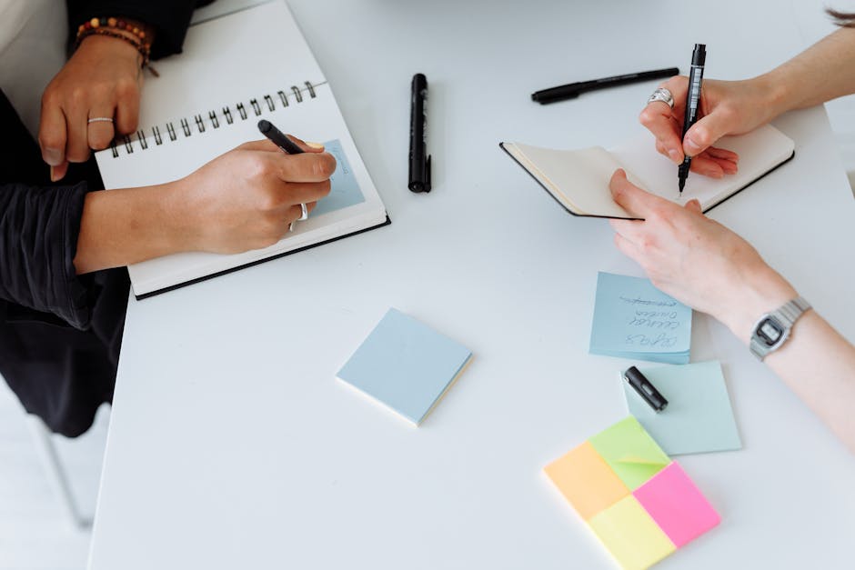 Person writing ideas on paper with creative brainstorming setup