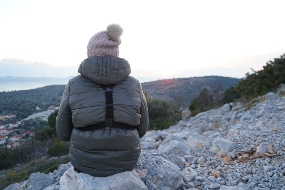 Person hiking alone on a mountain ridge at sunrise