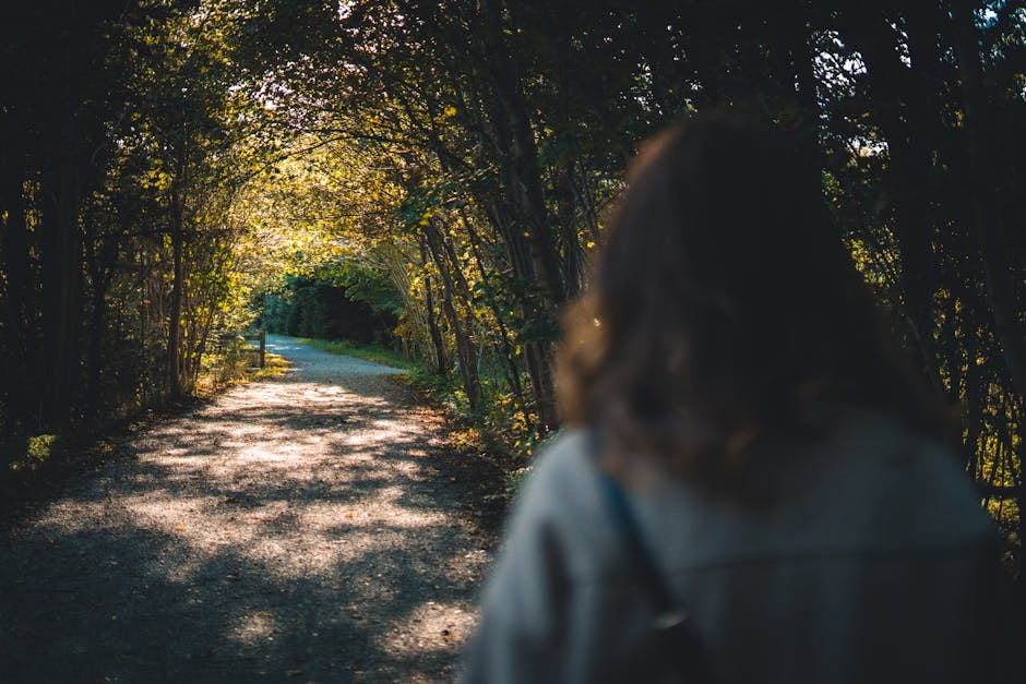 Person walking on a quiet forest path, symbolizing a simpler and more intentional life