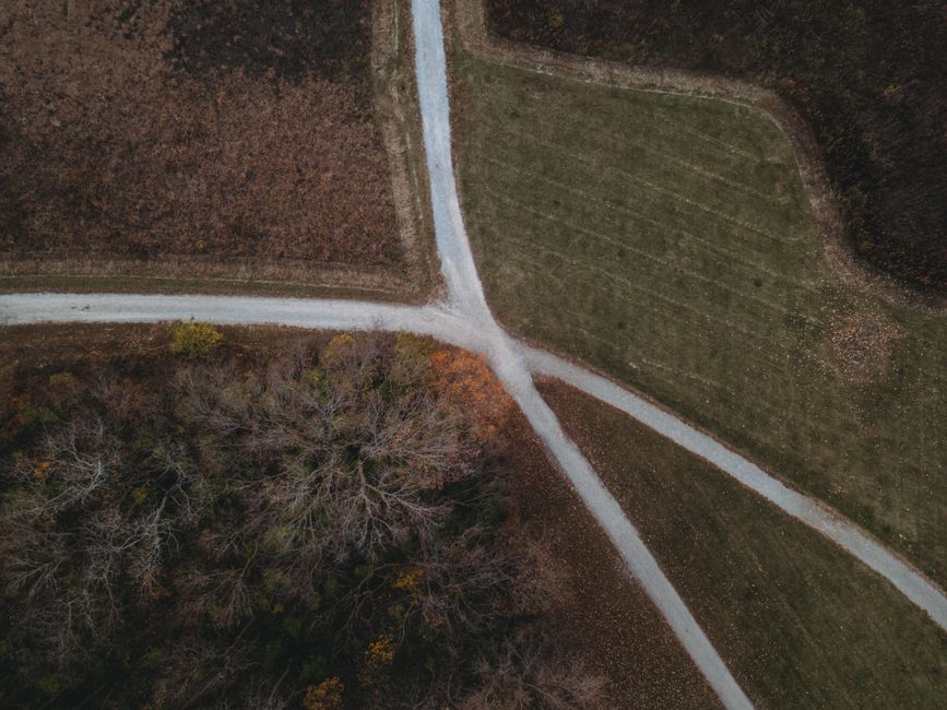 Person standing at a crossroads in a landscape