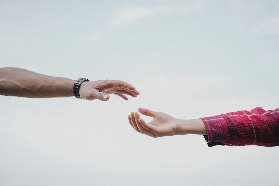 Compassion vs empathie : la différence qui change tout (neurosciences, burnout, vie quotidienne) Two hands reaching towards each other, symbolizing connection and support.