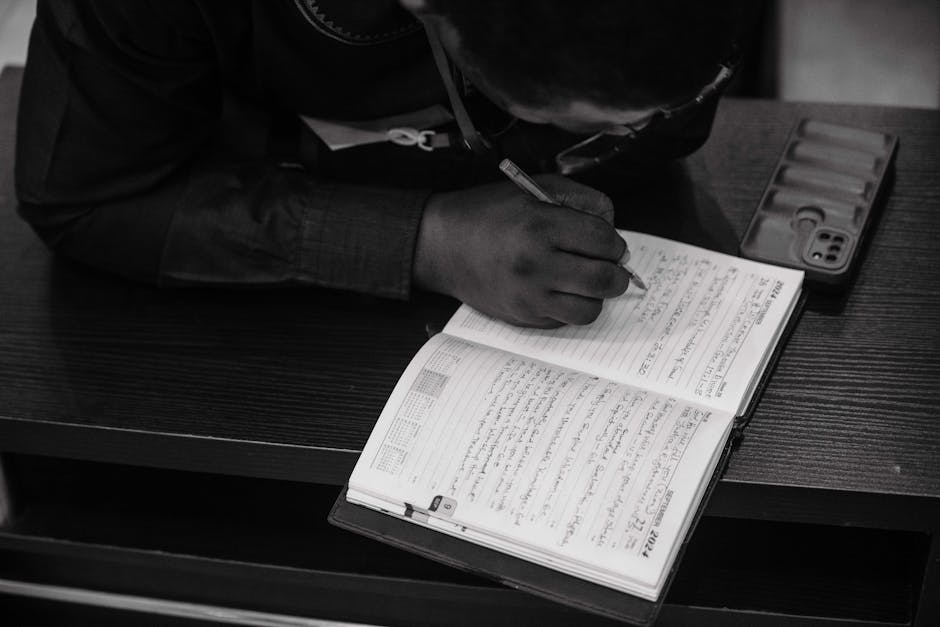 Person writing in a journal with a thoughtful, introspective mood