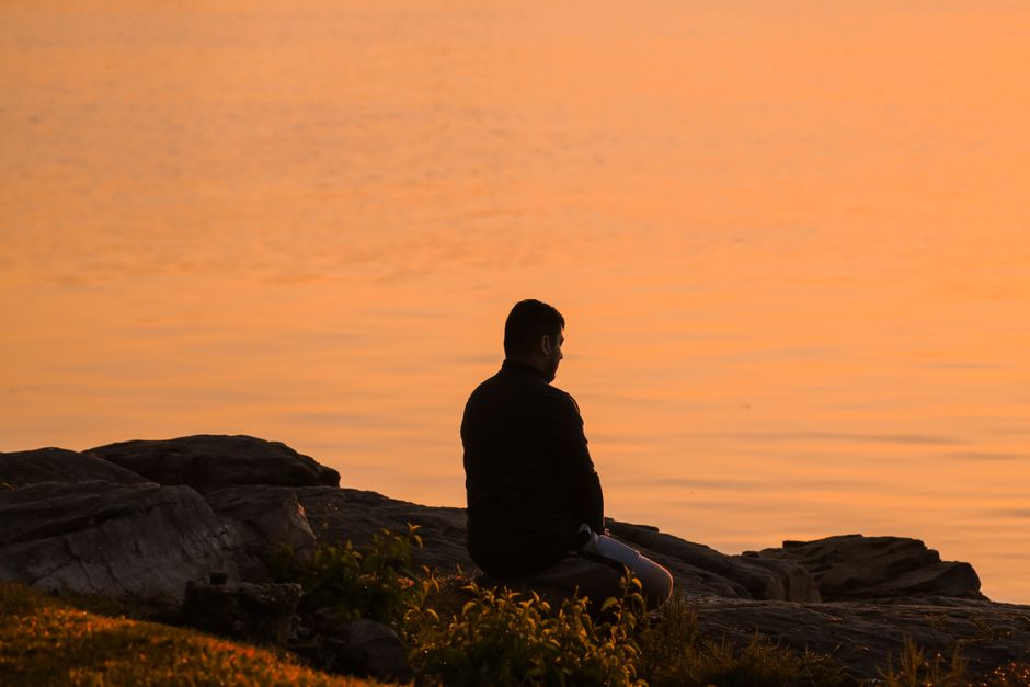Personne en méditation ou en contemplation face à la nature, symbolisant l’auto-transcendance