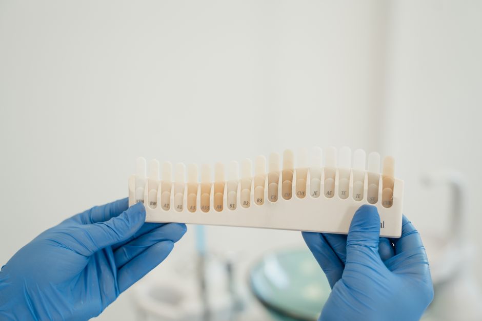 L’Ikigaï au travail : comment aligner passion et profession sans perdre pied Dentist using a tooth shade guide to match patient's tooth color accurately during treatment.