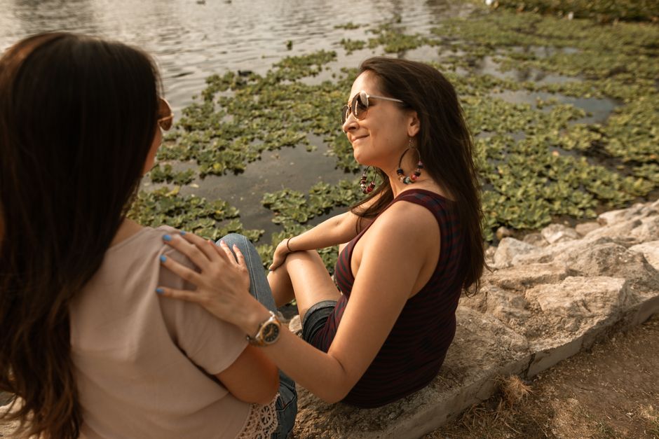 Two close friends talking supportively outdoors