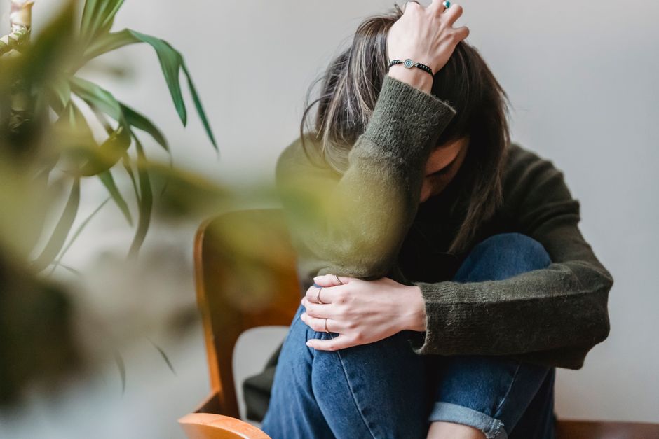 Person sitting alone looking worried, representing climate anxiety and psychological stress
