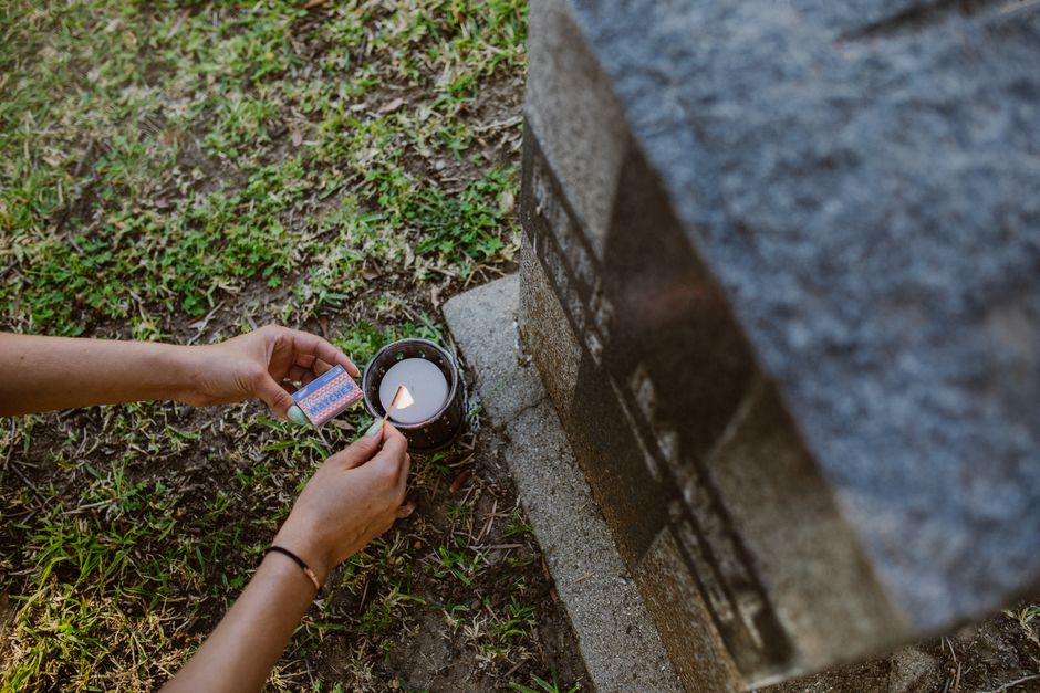 Hands holding a photo and candle in remembrance