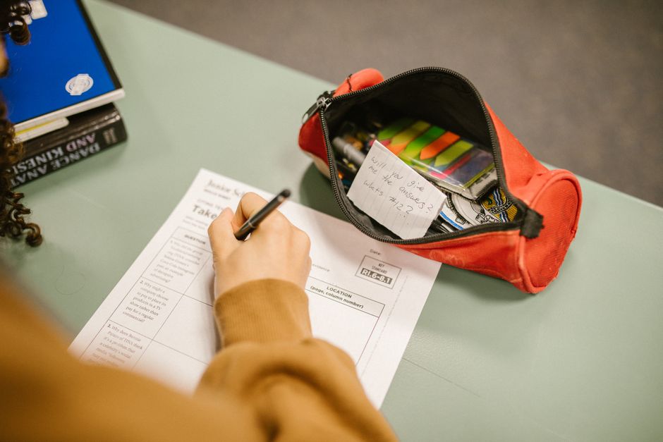 La saillance de la mortalité : penser à la mort pour éclaircir le but de sa vie A college student using cheat notes during an exam with visible test paper and pencil case.