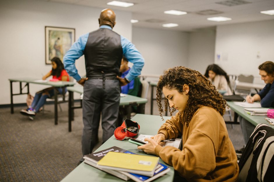 La psychologie du pardon : comment lâcher prise guérit Students in a classroom setting with a teacher proctoring. Educational environment.